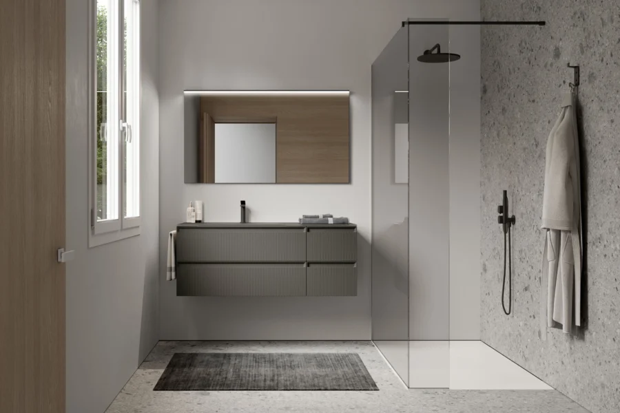 Kompaktní koupelnová sestava Play Ideagroup ideální pro městské byty. Barevně sladěná svislá skříňka, zrcadlo s osvětlením a odolná umyvadlová deska v nabídce ASSO.